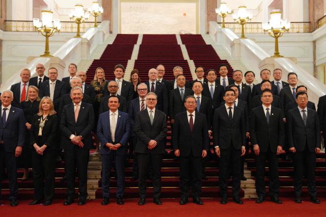 British Prime Minister Keir Starmer (5th-L) and Chinese Premier Li Qiang (4th-R) pose with their business delegations at the Great Hall of the People in Beijing on January 29, 2026. Chinese President Xi Jinping told Starmer their countries must "strengthen" ties to counter geopolitical headwinds, as the leaders met in Beijing on January 29. (Photo by Carl Court / POOL / AFP)
