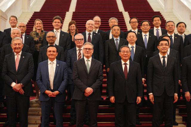 British Prime Minister Keir Starmer (C) and Chinese Premier Li Qiang pose with their business delegations at the Great Hall of the People in Beijing on January 29, 2026. Chinese President Xi Jinping told Starmer their countries must "strengthen" ties to counter geopolitical headwinds, as the leaders met in Beijing on January 29. (Photo by Carl Court / POOL / AFP)