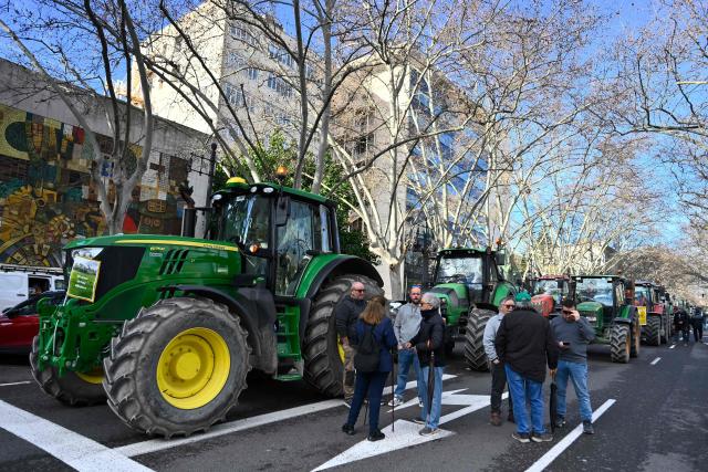 Farmers stand next to their tractors during a protest against the EU-Mercosur trade deal and the economic pressures facing the agricultural sector in Valencia, on January 29, 2026. (Photo by Jose JORDAN / AFP)