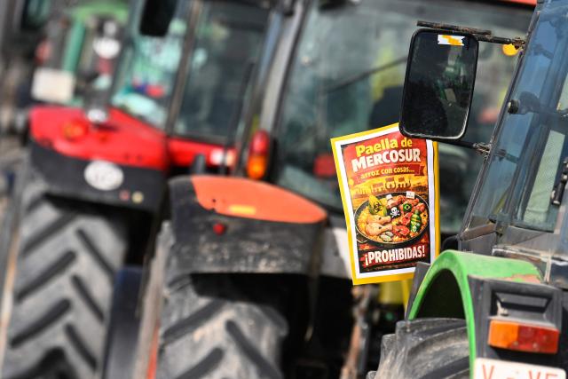 A placard reading "Mercosur paella. Rice with... forbidden things!" is seen on a tractor during a protest against the EU-Mercosur trade deal and the economic pressures facing the agricultural sector in Valencia, on January 29, 2026. (Photo by Jose JORDAN / AFP)