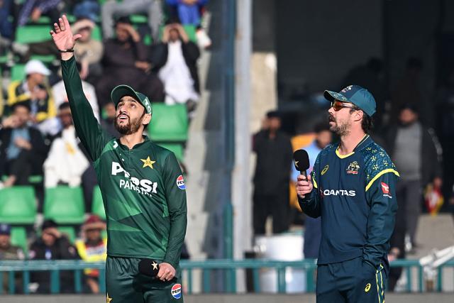 Pakistan's captain Salman Agha (L) tosses the coin as his Australian counterpart Travis Head watches at the start of the first Twenty20 international cricket match between Pakistan and Australia at the Gaddafi Cricket Stadium in Lahore on January 29, 2026. (Photo by Arif ALI / AFP)