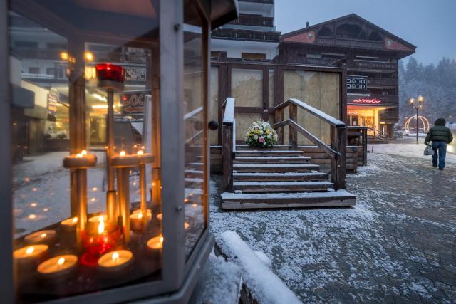 This photograph shows a bouquet of flowers left by members of the Italy's alpine ski team, which takes part in the World Cup races in Crans-Montana, at the entrance of the bar Le Constellation in tribute to the victims of the fire that ripped through the venue on New Year's Eve celebrations, in the Alpine ski resort town of Crans-Montana on January 28, 2026. The fire on January 1 at the bar Le Constellation left 40 people dead -- including nine French and six Italian nationals -- and injured 116 others, most of them teenagers. (Photo by Fabrice COFFRINI / AFP)