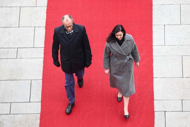 German Chancellor Friedrich Merz and Lithuania's Prime Minister Inga Ruginiene review a military honor guard during a welcome ceremony in front of the Chancellery in Berlin, on January 29, 2026. (Photo by Liesa Johannssen / POOL / AFP)