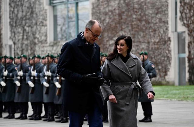 German Chancellor Friedrich Merz (L) and Lithuania's Prime Minister Inga Ruginiene review a military honor guard during an official welcome ceremony in front of the Chancellery in Berlin, Germany, on January 29, 2026. (Photo by Tobias SCHWARZ / AFP)