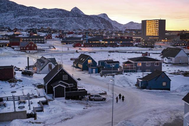 People walk in a snow-covered street in a residential area of Nuuk, Greenland, on January 29, 2026. (Photo by Ina FASSBENDER / AFP)