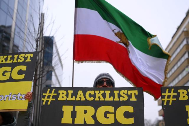 Supporters of the National Council of Resistance of Iran wave pre-1979 Islamic Revolution Iranian flags and hold placards reading "Blacklist Islmamic Revolutionary Guard Corps" as they take part in a demonstration in support of the Iranian people in Brussels on January 29, 2026. (Photo by Nicolas TUCAT / AFP)