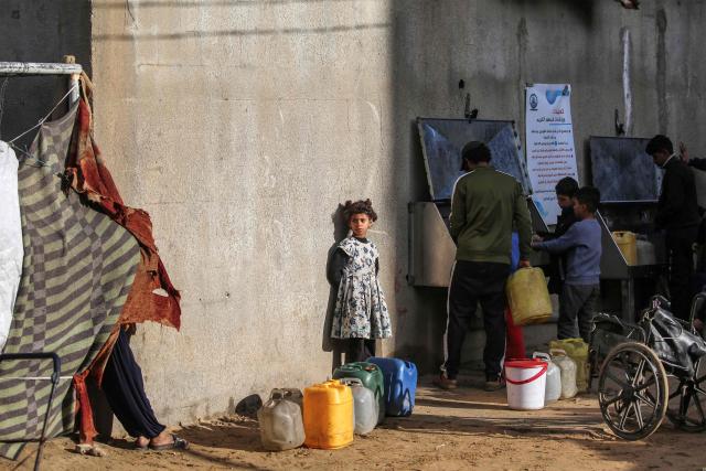 A young girl queues as others fill up containers with water from a public cistern, in the Nuseirat camp for Palestinian refugees north of Deir al-Balah in the central Gaza Strip on January 29, 2026. Since October 10, a fragile US-sponsored truce in Gaza has largely halted the fighting between Israeli forces and Hamas, but both sides have alleged frequent violations. (Photo by EYAD BABA / AFP)