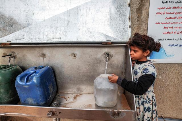 A young girl fills up container with water from a public cistern, in the Nuseirat camp for Palestinian refugees north of Deir al-Balah in the central Gaza Strip on January 29, 2026. Since October 10, a fragile US-sponsored truce in Gaza has largely halted the fighting between Israeli forces and Hamas, but both sides have alleged frequent violations. (Photo by EYAD BABA / AFP)