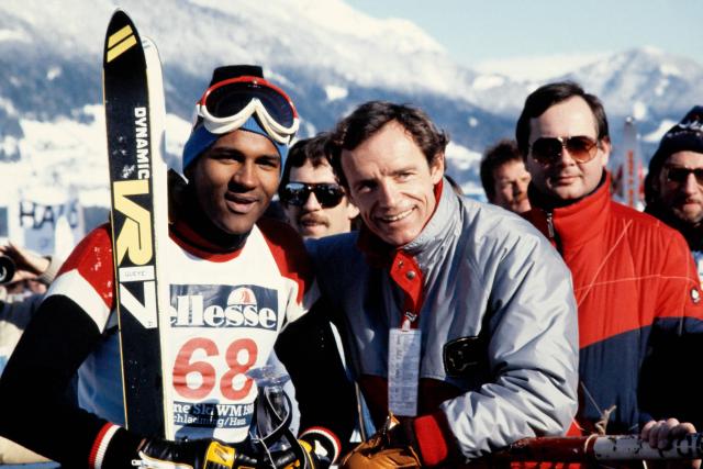 (FILES) French skier Jean-Claude Killy (R) and Senegalese skier Lamine Gueye pose during the World Ski Championships in Schladming on February 1, 1982. In 1984, Lamine Gueye wrote a chapter of Olympic history in Sarajevo: he was the first Black African to take part in the Winter Games. Four decades later, he strapped on his skis again to race down the slopes of Mount Bjelaљnica, where he had boldly defended Senegal’s colors. (Photo by Georges BENDRIHEM / AFP)