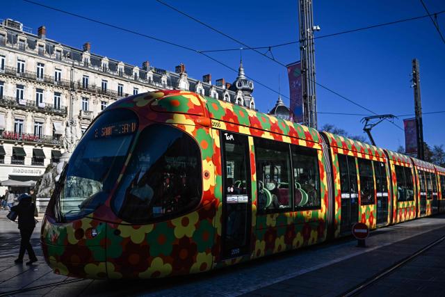 A pedestrian walks past a tramway in Montpellier, southern France, on January 29, 2026. Free transportation is a popular idea for the March municipal elections in many cities. But the promises vary greatly, and some candidates denounce it as “vote fishing” or even a “false good idea.” Initially limited to young people and seniors, then to weekends, this promise made in 2020 for Montpellier has, for a little over two years now, been available on buses and trams to all 500,000 residents of this metropolitan area. (Photo by Gabriel BOUYS / AFP)