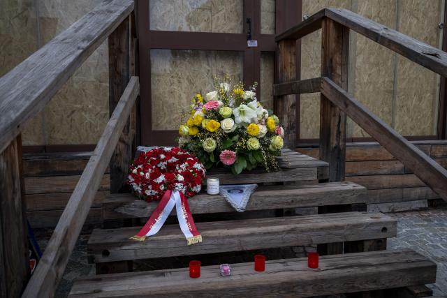 This photograph shows flowers left by members of the Italy's and Autria's alpine ski team  - which take part in the World Cup races in Crans Montana - in front of the bar "Le Constellation" to pay tribute to the victims of the fire that ripped through the venue on New Year's Eve celebrations, in the Alpine ski resort of Crans-Montana on January 29, 2026. The fire on January 1 at the bar "Le Constellation" left 40 people dead -- including nine French and six Italian nationals -- and injured 116 others, most of them teenagers. (Photo by Fabrice COFFRINI / AFP)