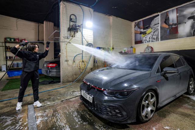 Hanadi Hadya, a 36-year-old Palestinian woman who opened her own carwash, sprays a vehicle at her shop in Beit Jala in the centre of the occupied West Bank on January 29, 2026. (Photo by HAZEM BADER / AFP)