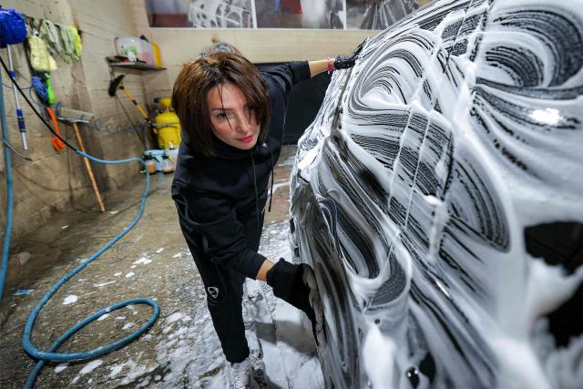 Hanadi Hadya, a 36-year-old Palestinian woman who opened her own carwash, washes a vehicle with foam soap at her shop in Beit Jala in the centre of the occupied West Bank on January 29, 2026. (Photo by HAZEM BADER / AFP)