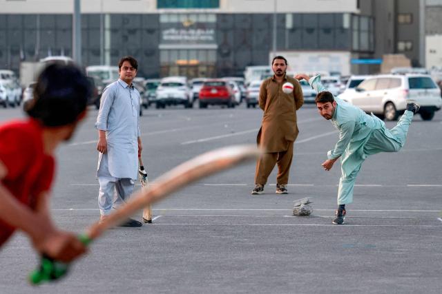 Members of Qatar's Pakistani community play cricket at a car park at sunset in Doha on January 29, 2026. (Photo by Karim JAAFAR / AFP)