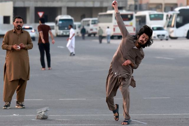 Members of Qatar's Pakistani community play cricket at a car park at sunset in Doha on January 29, 2026. (Photo by Karim JAAFAR / AFP)