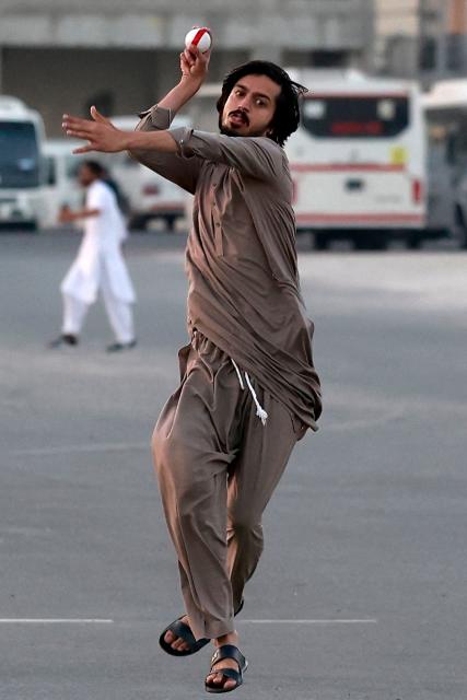 Members of Qatar's Pakistani community play cricket at a car park at sunset in Doha on January 29, 2026. (Photo by Karim JAAFAR / AFP)