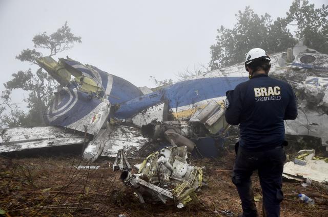 A search and rescue member inspects the wreckage of a plane that crashed, killing 15 people, in La Playa de Belen municipality, Norte de Santander department, Colombia, on January 29, 2026. A twin-propeller aircraft carrying 15 people, including a Colombian lawmaker, crashed in a mountainous region near the Venezuelan border on January 28, killing all passengers and crew, according to authorities in Bogota. The plane took off from the Colombian border city of Cucuta and lost contact with air traffic control shortly before it was due to land in nearby Ocana around noon. (Photo by Schneyder Mendoza / AFP)