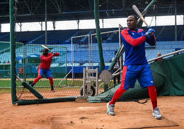 Cuban baseball player Yoelquis Guibert Steven (R) take part in a training session at Latin American Stadium in Havana on January 29, 2026, ahead of the VI World Baseball Classic, which will be held next March. (Photo by YAMIL LAGE / AFP)