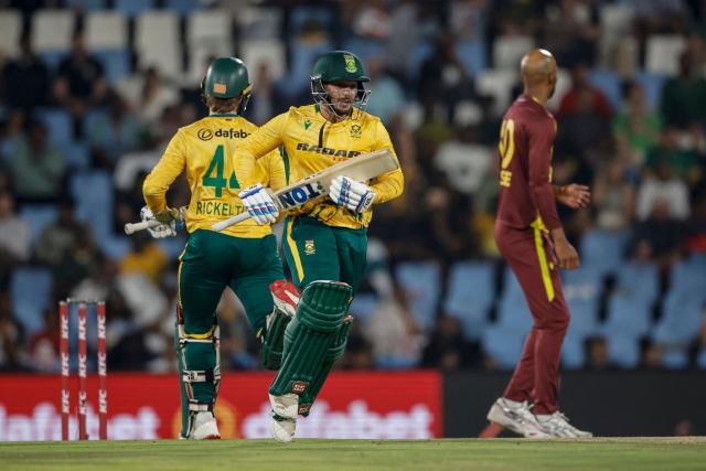 South Africa's Quinton de Kock (C) and South Africa's Ryan Rickelton (L) run between the wickets during the second Twenty20 international cricket match between South Africa and West Indies at SuperSport Park in Centurion on January 29, 2026. (Photo by PHILL MAGAKOE / AFP)