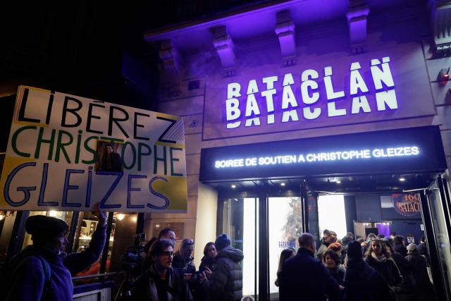 French activist Jean-Baptiste Redde, also known as Voltuan holds a placard reading "Free Gleizes !" referring to jailed French sports journalist Christophe Gleizes ahead of a Reporters Without Borders (RSF) evening in solidarity with Christophe Gleizes at the Bataclan music hall in Paris on January 29, 2026. Gleizes was arrested in May 2024 while travelling to northeastern Algeria's Kabylia region to write about the country's most decorated football club, Jeunesse Sportive de Kabylie. (Photo by STEPHANE DE SAKUTIN / AFP)