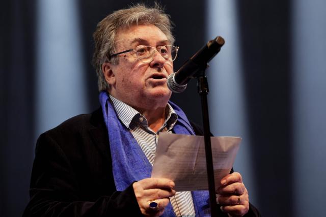 Stepfather of jailed French journalist Christophe Gleizes, Francis Godard delivers a speech during a Reporters Without Borders (RSF) evening in solidarity with jailed French sport journalist Christophe Gleizes at Bataclan music hall in Paris on January 29, 2026. Gleizes was arrested in May 2024 while travelling to northeastern Algeria's Kabylia region to write about the country's most decorated football club, Jeunesse Sportive de Kabylie. (Photo by STEPHANE DE SAKUTIN / AFP)