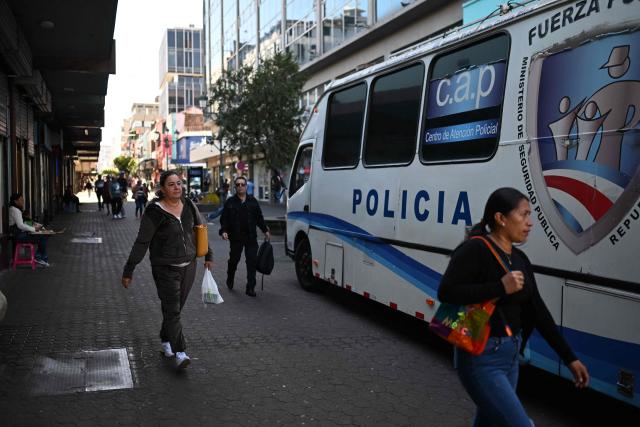People walk past a police vehicle in downtown San Jose on January 29, 2026. Right-wing politician Laura Fernandez appears set to win Costa Rica's presidential election in the first round, according to two opinion polls published on January 21. (Photo by Marvin RECINOS / AFP)