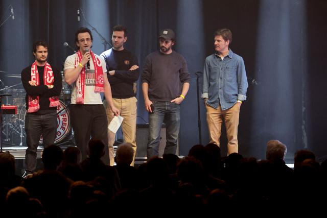 Friend of French journalist Christophe Gleizes, Pierre de la Saussay (L) delivers a speech flanked by friends of Christophe Gleizes during a Reporters Without Borders (RSF) evening in solidarity with jailed French sports journalist Christophe Gleizes at Bataclan music hall in Paris on January 29, 2026. Gleizes was arrested in May 2024 while travelling to northeastern Algeria's Kabylia region to write about the country's most decorated football club, Jeunesse Sportive de Kabylie. (Photo by STEPHANE DE SAKUTIN / AFP)