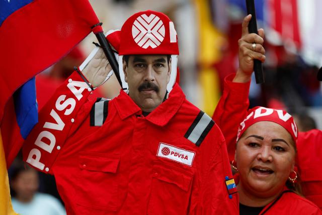 A worker of Venezuelan state oil company PDVSA holds an image of ousted President Nicolas Maduro during a march called by the United Socialist Party of Venezuela (PSUV) in support of the Hydrocarbons Law and demanding the release of Maduro, in Caracas on January 29, 2026. (Photo by Pedro MATTEY / AFP)