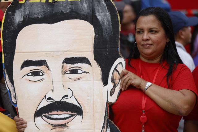 A woman holds an image of ousted President Nicolas Maduro during a march called by the United Socialist Party of Venezuela (PSUV) in support of the Hydrocarbons Law and demanding the release of Maduro, in Caracas on January 29, 2026. (Photo by Pedro MATTEY / AFP)