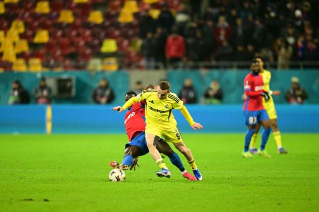 FCSB's Ghanaian midfielder #42 Baba Alhassan (L) and Fenerbahce's Turkish forward #09 Muhammed Kerem Akturkoglu vie for the ball during the UEFA Europa League first round day 8 football match FC Steaua Bucharest v Fenerbahce in Bucharest on January 29, 2026. (Photo by Daniel MIHAILESCU / AFP)