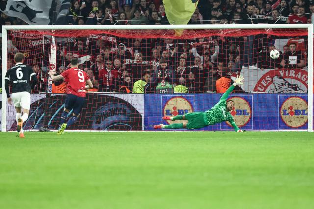 Lille's French forward #09 Olivier Giroud (L) scores a penalty against SC Freiburg's German goalkeeper #01 Noah Atubolu (R) during the UEFA Europa League - League phase, Matchday 8 - football match between LOSC Lille and SC Freiburg at the Pierre Mauroy Stadium in Villeneuve d'Ascq, northern France, on January 29, 2026. (Photo by Sameer Al-DOUMY / AFP)