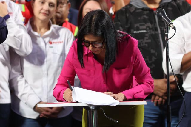 Venezuela’s interim President Delcy Rodriguez signs the Reform of the Organic Law on Hydrocarbons outside the Miraflores Presidential Palace in Caracas on January 29, 2026. Venezuela adopted a reform opening its nationalized oil sector to private investment on January 29 as it moves to appease the United States following the toppling of leader Nicolas Maduro. (Photo by Pedro MATTEY / AFP)