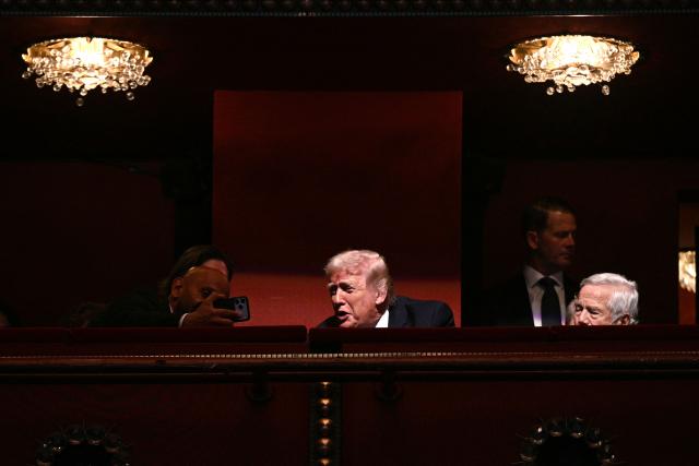 US President Donald Trump (C) chats with guests while attending the world premiere of Amazon MGM Studios' "Melania" at the Kennedy Center in Washington, DC, on January 29, 2026. (Photo by Brendan SMIALOWSKI / AFP)