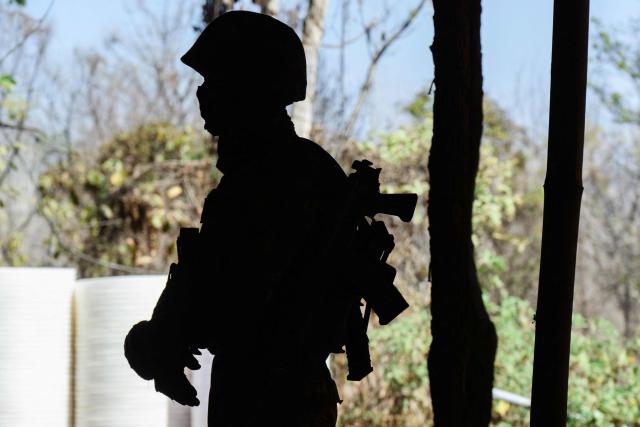 In this photo taken on January 24, 2026, a soldier stands guard during a press tour of a drug production site southwest of Mongyai, northern Shan State, that was captured by the Myanmar military. The Southeast Asian country has long been a hive for illegal drug trade, but analysts say the civil war triggered by a 2021 military coup has increased production and trafficking. (Photo by ANTHONY WALLACE / AFP)