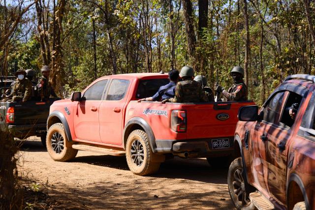 In this photo taken on January 24, 2026, soldiers are driven in a convoy during a press tour of a drug production site southwest of Mongyai, northern Shan State, that was captured by the Myanmar military. The Southeast Asian country has long been a hive for illegal drug trade, but analysts say the civil war triggered by a 2021 military coup has increased production and trafficking. (Photo by ANTHONY WALLACE / AFP)