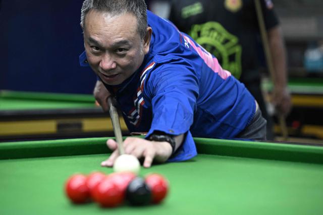Former snooker player Wattana Pu-Ob-Orm, known professionally as James Wattana, plays at a snooker hall as he campaigns for the United Thai Nation Party ahead of the general election in Bangkok on January 29, 2026. (Photo by Lillian SUWANRUMPHA / AFP)