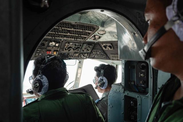 In this photo taken on January 24, 2026, pilots fly a military Mi-17 helicopter transporting members of the press for a tour of a drug production site in northern Shan State that was captured by the Myanmar military. The Southeast Asian country has long been a hive for illegal drug trade, but analysts say the civil war triggered by a 2021 military coup has increased production and trafficking. (Photo by ANTHONY WALLACE / AFP)