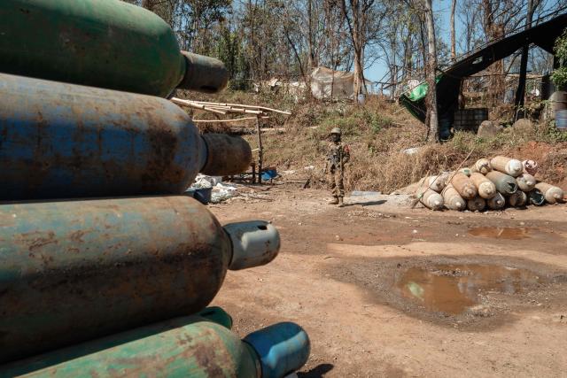 In this photo taken on January 24, 2026, a soldier stands guard during a press tour of a drug production site southwest of Mongyai, northern Shan State, that was captured by the Myanmar military. The Southeast Asian country has long been a hive for illegal drug trade, but analysts say the civil war triggered by a 2021 military coup has increased production and trafficking. (Photo by ANTHONY WALLACE / AFP)