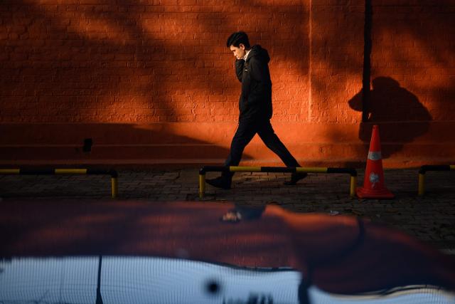 A man walks along a street in New Delhi on January 30, 2026. (Photo by Manan VATSYAYANA / AFP)