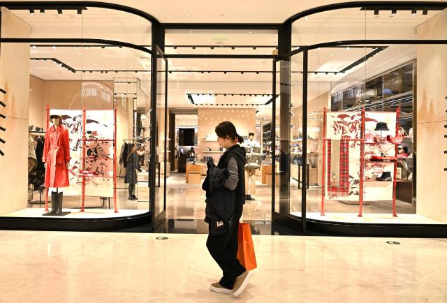 A woman walks past a British Burberry shop at a shopping mall in Beijing on January 30, 2026. (Photo by ADEK BERRY / AFP)