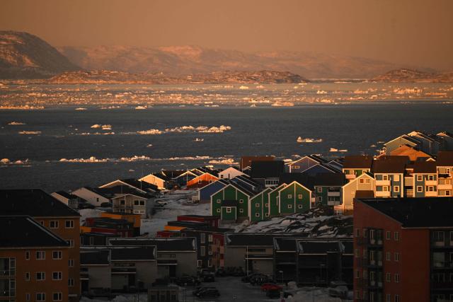 Houses of a residential area and ice floes floating on the sea are seen at the coastline of Nuuk, Greenland, on January 29, 2026. (Photo by Ina FASSBENDER / AFP)