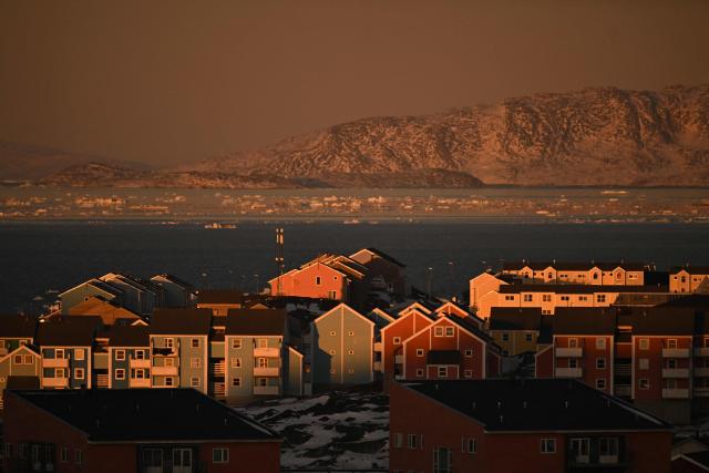 Houses of a residential area and ice floes floating on the sea are seen at the coastline of Nuuk, Greenland, on January 29, 2026. (Photo by Ina FASSBENDER / AFP)