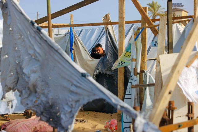 TOPSHOT - People inspect one of the tents, housing displaced Palestinians in the Mawasi area of Khan Yunis, in southern Gaza Strip, on January 30, 2026, following Israeli strikes. The US-brokered ceasefire, which sought to halt the fighting between Israel and Hamas sparked by the group's October, 2023 attack has been in place for more than three months despite both sides accusing the other of repeated violations. (Photo by Bashar Taleb / AFP)