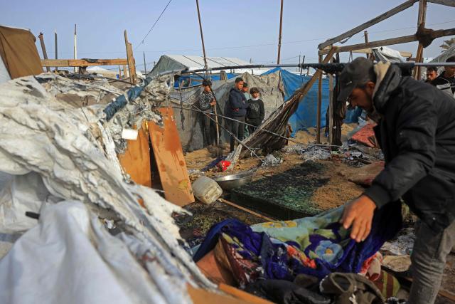 People inspect one of the tents, housing displaced Palestinians in the Mawasi area of Khan Yunis, in southern Gaza Strip, on January 30, 2026, following Israeli strikes. The US-brokered ceasefire, which sought to halt the fighting between Israel and Hamas sparked by the group's October, 2023 attack has been in place for more than three months despite both sides accusing the other of repeated violations. (Photo by Bashar Taleb / AFP)