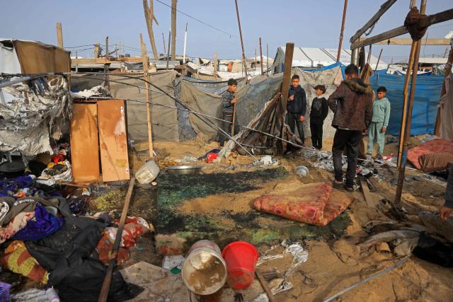 People inspect one of the tents, housing displaced Palestinians in the Mawasi area of Khan Yunis, in southern Gaza Strip, on January 30, 2026, following Israeli strikes. The US-brokered ceasefire, which sought to halt the fighting between Israel and Hamas sparked by the group's October, 2023 attack has been in place for more than three months despite both sides accusing the other of repeated violations. (Photo by Bashar Taleb / AFP)