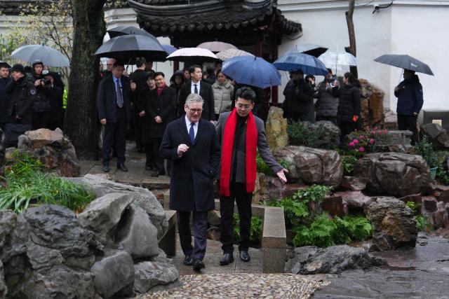 Britain's Prime Minister Keir Starmer (L) visits Yuyuan Gardens in Shanghai on January 30, 2026. (Photo by Carl Court / POOL / AFP)