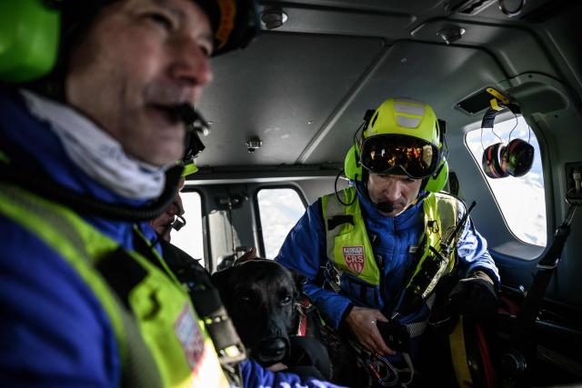 Members of the CRS Alpes Grenoble mountain rescue team fly back to the Alpe d'Huez altiport rescue station in a Securite Civile helicopter (emergency management) after an avalanche emergency response rescue mission in an off-piste area of the Ecrins massif, French Alps on January 29, 2026. (Photo by JEFF PACHOUD / AFP)