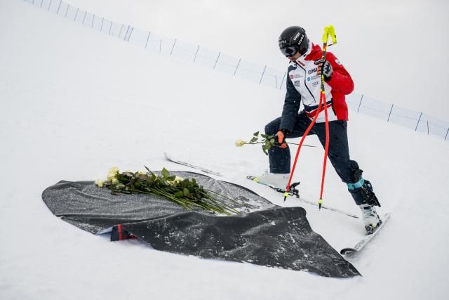 France's Nils Alphand lays flowers to pay tribute to the victim of the fire that ripped through the venue on New Year's Eve celebrations, in the Alpine ski resort town of Crans Montana, Switzerland, on January 30, 2026 ahead of the FIS Alpine Ski World Cup 2025-2026 event. The fire on January 1 at the bar Le Constellation left 40 people dead -- including nine French and six Italian nationals -- and injured 116 others, most of them teenagers. (Photo by Fabrice COFFRINI / AFP)