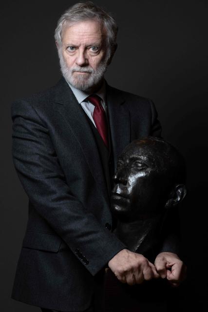 French actor Francis Huster poses with a bust of the French actor Louis Jouvet during a photo session at the Theatre Antoine in Paris on January 28, 2026. He hopes to keep performing "for the next ten years": at 78, Francis Huster is returning to the stage as the therapist in the play "En Therapie", a theatrical adaptation of the eponymous series, delighted to refresh his craft alongside the younger generation. (Photo by JOEL SAGET / AFP)