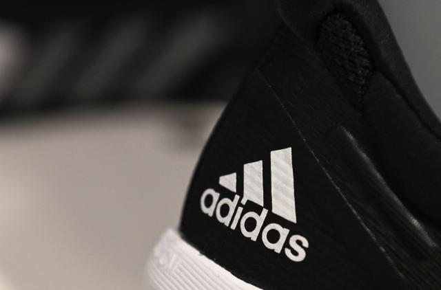 (FILES) The logo of the German sports equipment maker Adidas is pictured on a shoe prior to the company's annual press conference in Herzogenaurach, southern Germany on March 8, 2023. Shares in Adidas jumped sharply on January 30, 2026 after the German sportswear giant posted record 2025 sales and announced a one-billion-euro ($1.2 billion) share buyback, defying the turmoil unleashed by US tariffs. (Photo by Christof STACHE / AFP)